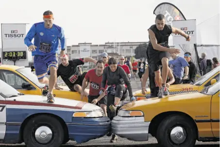  ?? Photos by Alex Washburn / Special to The Chronicle ?? Racers scramble over taxis, one of the many types of obstacles, near the end of the 10.2-mile Men’s Health Urbanathlo­n in S.F.