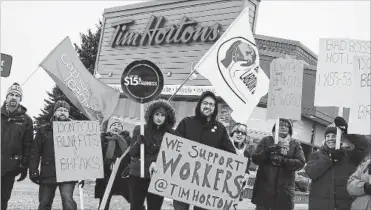  ?? METROLAND SHANE MACDONAL ?? People gather at a Barrie Tim Hortons to show solidarity with workers who have seen cuts to paid breaks and health benefits, as well as reduced hours, after the minimum wage increased.