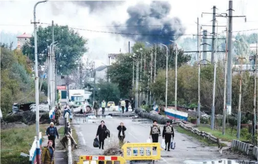  ?? Agence France-presse ?? ±
Residents evacuate as Russian military shells a bridge over the Oskil River in Kupiansk, Kharkiv region, on Saturday. Kupiansk, which was recaptured by Ukrainian forces, is witnessing heavy fighting.