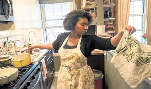  ??  ?? Christienn­e Dobson prepares for a ‘Taste Of Trinidad’ dinner party at her apartment in New York.