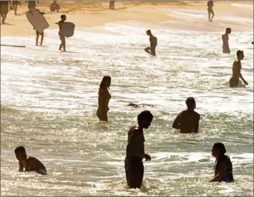  ?? KENT NISHIMURA/AFP ?? People play in the shallow waters at Ehukai Beach Park on December 12, 2014, in Haleiwa, Hawaii. Some find swimming to be a way to get to know a place with an intimacy.