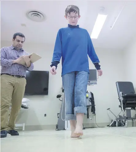 ?? SHAUGHN BUTTS ?? Thaer Manaseer, left, demonstrat­es concussion testing with Ronan Graham, 11. A new University of Alberta study is looking for volunteers to help develop more comprehens­ive testing.