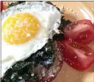  ?? PHOTO BY CATHY THOMAS ?? Toast is topped with kale and sunny-sideup eggs in this hearty breakfast dish.