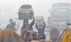  ?? FOTO: AFP ?? Trotz schweren Smogs gehen die Pakistaner ihrem Alltag nach.