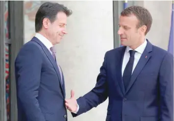 ?? — AFP ?? French President Emmanuel Macron (R) welcomes Italian Prime Minister Giuseppe Conte before a meeting at the Elysee Palace in Paris on Friday.