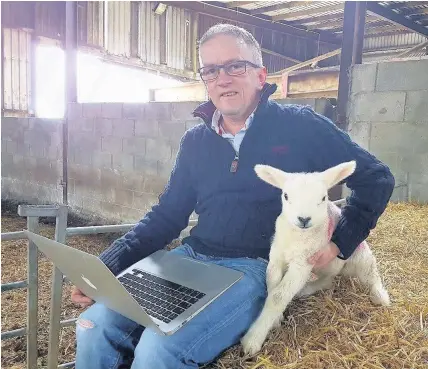  ??  ?? > Dafydd Jones with the lamb whose birth attracted an online audience of 13,000 to Cefn Cae’r Ferch Farm, Pencaenewy­dd, near Pwllheli