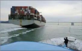  ?? ERIC RISBERG — THE ASSOCIATED PRESS FILE ?? A man standing on the bow of a Golden Gate Ferry takes a picture of a container ship as it heads toward the San Francisco-Oakland Bay Bridge in San Francisco. The U.S. economy grew at a solid 2.9 percent annual rate in the final three months of last...