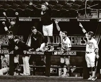  ?? Wally Skalij / Los Angeles Times ?? The Dodgers’ dugout celebrates Mookie Betts’ solo home run in the sixth inning in Game 1 at Globe Life Field in Arlington. The Dodgers, in their third World Series in four years, are seeking their first title since 1988.