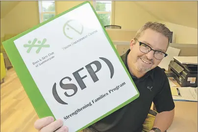  ?? COLIN MACLEAN/TC MEDIA ?? Jason (Lefty) Gallant holds up a training manual for the strengthen­ing families program being introduced at the Summerside Youth Engagement Centre.