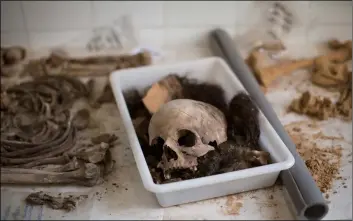  ??  ?? A skull with other bones of a victim’s body is classified by anthropolo­gists following an exhumation of a mass grave at the cemetery of Paterna, near Valencia, Spain, on Tuesday. AP Photo/emIlIo morenAttI