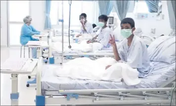  ?? THAILAND GOVERNMENT SPOKESMAN BUREAU VIA AP ?? Three of the 12 boys are seen recovering in their hospital beds after being rescued from a flooded cave in Thailand.