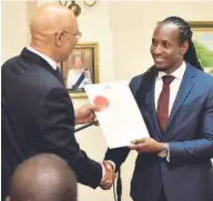  ??  ?? Alando Terrelonge receives his instrument of appointmen­t from Governor General Sir Patrick Allen.
