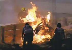  ?? BRYNN LENNON AP ?? The parts of Haas driver Romain Grosjean’s car are burning after he crashed during the Formula One race in Bahrain Internatio­nal Circuit in Sakhir, Bahrain on Sunday.