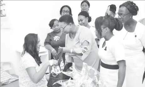  ?? (DPI photo) ?? Minister of Public Health, Volda Lawrence (right) greets and hands over a congratula­tory hamper to Taysuwatti­e Budhu, mother of the first Christmas Day baby at GPHC in the presence of nurses attached to the maternity unit.