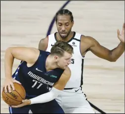  ?? Associated Press ?? PRESSURE — The Clippers’ Kawhi Leonard, right, applies pressure on the Dallas Mavericks’ Luka Doncic (77) during the second half on Thursday in Lake Buena Vista, Fla. Leonard scored 29 points to help the Clippers to a 126-111 victory.