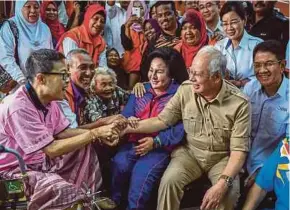  ?? BERNAMA PIC ?? Prime Minister Datuk Seri Najib Razak and his wife, Datin Seri Rosmah Mansor, sharing a light moment with flood victims at an evacuation centre in Seberang Prai yesterday. Present is state Federal Action Council chairman Datuk Seri Zainal Abidin Osman...