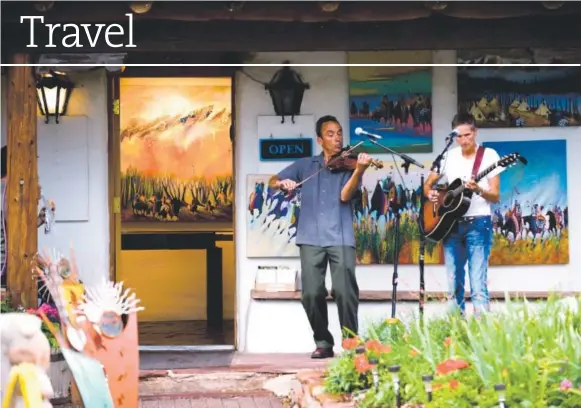  ?? Photo provided by Tourism Santa Fe ?? Live music greets visitors outside a gallery on Canyon Road in Santa Fe.