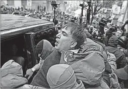  ??  ?? Ukrainian security officers try to place Mikhail Saakashvil­i into a van, but his supporters halted the vehicle and freed Saakashvil­i. The security forces had first removed Saakashvil­i from a rooftop, from where he was trying to avoid arrest and rev up...