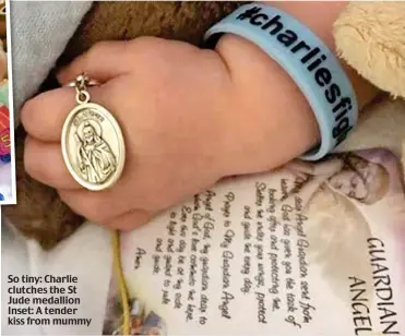  ??  ?? So tiny: Charlie clutches the St Jude medallion Inset: A tender kiss from mummy