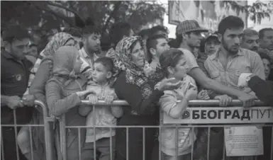  ?? SANTI PALACIOS/THE ASSOCIATED PRESS ?? Syrian refugees wait to be registered by police in the southern Serbian town of Presevo on Friday.