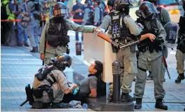  ?? — AP ?? Police personnel detain a protester on Wednesday during a march marking the 23rd anniversar­y of Hong Kong’s handover from Britain to China.