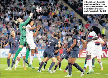  ??  ?? > Paris Saint-Germain goalkeeper Katarzyna Kiedrzynek punches the ball clear during last night’s match in Cardiff