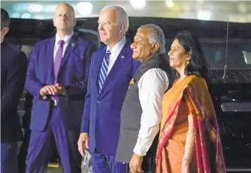  ?? EVAN VUCCI AP ?? President Joe Biden watches a group of dancers with Vani Sarraju Rao, joint secretary in the Ministry of External Affairs (right), and Vijay Kumar Singh, transporta­tion minister, as he arrives in India on Friday.