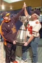  ?? CITIZEN FILE PHOTO ?? Long-time CFL fans Rick Brown, left, and Dale Kennedy celebrate hoisting the Grey Cup while it was visiting the Pine Centre in 2007.