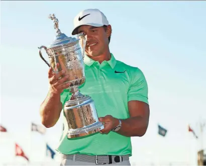  ?? ROB SCHUMACHER/AZCENTRAL SPORTS ?? Brooks Koepka poses with the trophy after winning the U.S. Open Sunday at Erin Hills. The victory gave Koepka his first major championsh­ip.