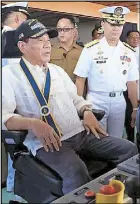  ??  ?? President Duterte tries out the captain’s chair as Navy commander Vice Admiral Ronald Mercado looks on. Duterte toured the BRP Davao del Sur in Davao City yesterday.