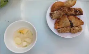  ??  ?? A mix of fried foods, including an egg roll and a sweet doughnut, at one of the stops on a street food tour of Hanoi.