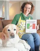  ?? ?? Di Lorenzo poses in her New Albany home with family dog Dolce and the Italian cookbook of her family’s favorite recipes. Dolce appears in the book and has tested much of Daniela’s cooking.