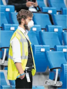  ?? FOTO: IMAGO IMAGES/POOLFOTO ?? Wenn in der neuen Saison Zuschauer in die Fußballsta­dien zurück dürfen, ist eine Maskenpfli­cht möglich – wie hier bei einem Ordner im Stadion der TSG Hoffenheim.