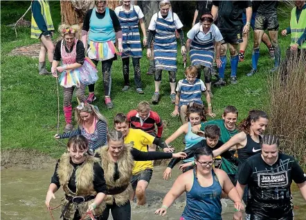  ?? PHOTOS: WARWICK SMITH/STUFF ?? Some of the 600 people who attempted The Mudder obstacle courses set off through the water.