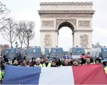  ?? REUTERS ?? PROTESTERS on the Champs Elysees below the heavily gaurded Arc de Triomphe in Paris yesterday. Monuments and normally bustling shopping meccas shut for fear of violence and destructio­n during the anti-government protests. |