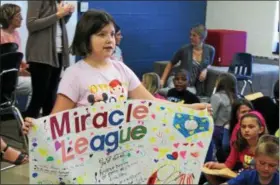  ?? KRISTI GARABRANDT — THE NEWS-HERALD ?? Sidney Sobochan, a second-grade student at Longfellow Elementary Schools, carries one of the posters the class worked on as a project-based learning experience to help promote The Miracle League of Lake County.