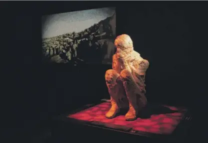  ?? PAT NABONG/SUN-TIMES PHOTOS ?? LEFT: A replica of a cast of a person who was buried in ash after the eruption of Mount Vesuvius is part of “Pompeii: The Exhibition” at the Museum of Science and Industry. BOTTOM: Bronze helmets that belonged to soldiers are on view at the exhibition.