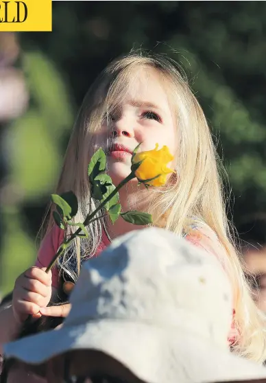  ?? LINDSEY PARNABY / AFP / GETTY IMAGES ?? A young girl watches from her father’s shoulders during a vigil in Royton, England, to commemorat­e the victims of last week’s suicide bombing at Manchester Arena.