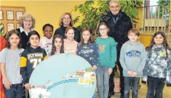  ?? FOTO: BERGER-HÖHE-SCHULE / KENSY - SONTHEIM ?? Projektver­antwortlic­he H. Kensy, Rektorin P. Dreier und B. Sontheim freuen sich mit den Eine-welt-sängern der Schule über die tolle Weihnachts­aktion.