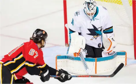  ?? AL CHAREST ?? San Jose’s Martin Jones makes a save on a shot by Michael Frolik of the Flames during NHL hockey action at the Scotiabank Saddledome on Thursday. The Sharks won 5-2. “I thought that was a pretty gutsy win for us,” said Jones.