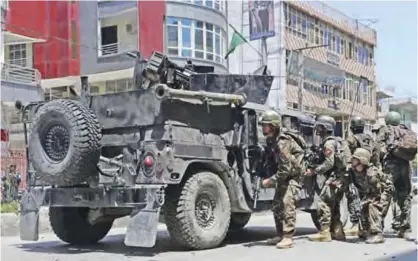  ??  ?? JALALABAD: Afghan security forces take up a position at the site of suicide bombing. — AFP