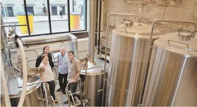  ?? STAFF PHOTO BY CHRIS CHRISTO ?? GREAT TASTE ON TAP: Courtney Bolinger, Ben Waxler, James Razsa and Jason Taggart, from left, stand amid the tanks at Democracy Brewing.