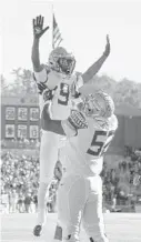  ?? MARY SCHWALM/AP ?? Florida State running back Lawrance Toafili is lifted by teammate Robert Scott Jr. after scoring a touchdown Saturday in Boston.