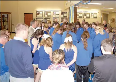  ?? Graham Thomas/Herald-Leader ?? Supporters of the John Brown University women’s basketball team gather around the players on Monday morning for a prayer led by Vice President Steve Beers just before the Golden Eagles departed for XNA for their flight to Billings, Mont., the site of...