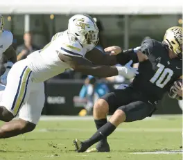  ?? PHELAN M. EBENHACK/AP ?? Georgia Tech defensive lineman Keion White, left, sacks Central Florida quarterbac­k John Rhys Plumlee during the 2022 season.