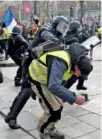  ?? AP PHOTO/RAFAEL YAGHOBZADE­H ?? A police officer in riot gear beats a demonstrat­or on the Champs-Elysees Avenue on Saturday in Paris.