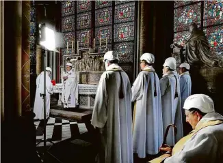  ?? Karine Perret/Reuters ?? Religiosos usam capacete durante cerimônia na catedral francesa