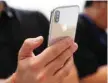  ?? — Reuters ?? Attendee checks out new iPhone X during an Apple launch event in Cupertino, California.