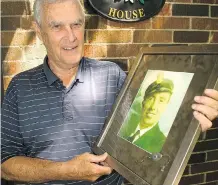  ??  ?? Thom McClenagha­n holds a portrait of his father, David, who has posthumous­ly received the Arctic Star, a medal for service on northern convoys.