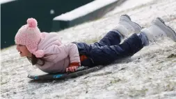  ?? Jason Fochtman / Staff photograph­er ?? Zoey Bodkin slides face-first down a hill in Kingwood after snow and ice covered Greater Houston.